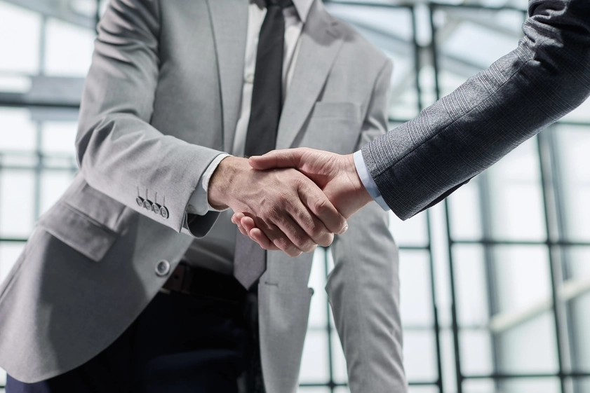 Acuerdo empresarial sellado con apretón de manos entre profesionales